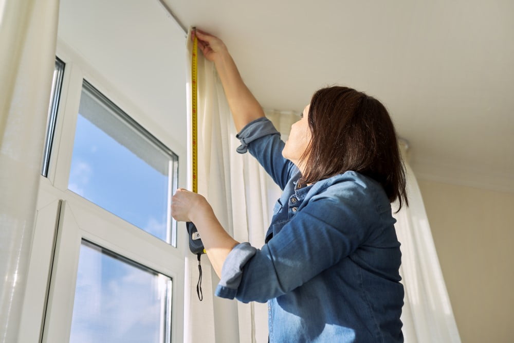 Kvinde der måler op til nye gardiner